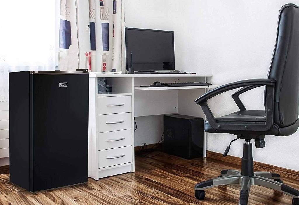 Small office refrigerator placed neatly in a modern workspace