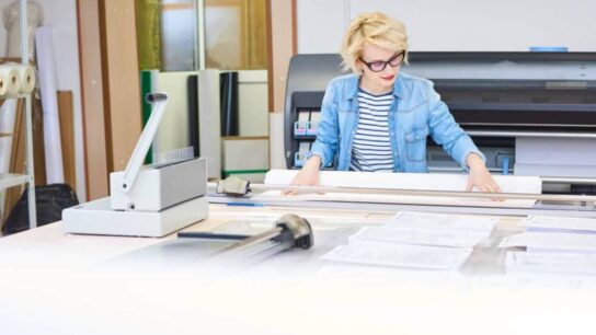 Stack of 11 x 17 printer paper on office desk for large format printing