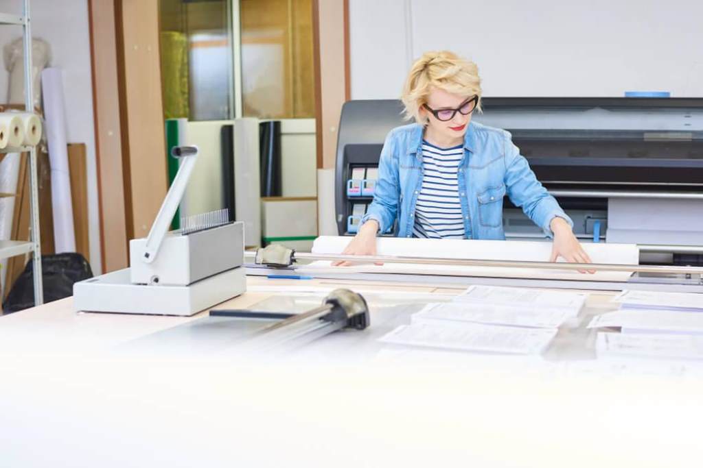 Stack of 11 x 17 printer paper on office desk for large format printing