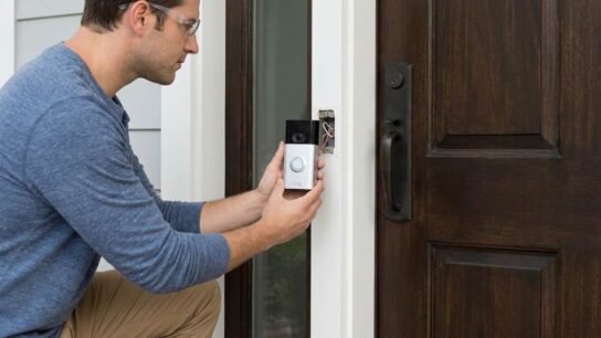 Homeowner installing a Ring doorbell safely beside a front door